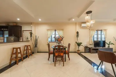 a kitchen and dining room with a table and chairs at Areca Holiday Home 1, Bangtao Beach in Ban Thalat Choeng Thale