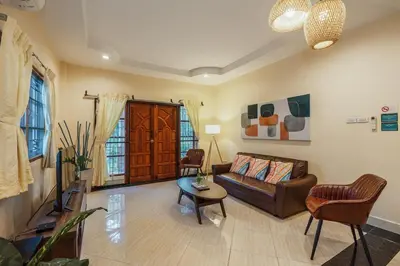 a living room with a couch and a table at Areca Holiday Home 1, Bangtao Beach in Ban Thalat Choeng Thale