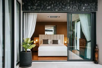 a bedroom with a white bed and a window at Botanic Modern loft Villa Private Pool 10 min BangTao in Ban Pak Lak