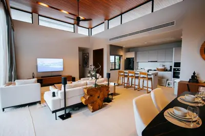 a living room with white furniture and a kitchen at Botanic Modern loft Villa Private Pool 10 min BangTao in Ban Pak Lak