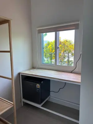 a window sill with a desk and a computer under it at Pangea Stay in Kathu