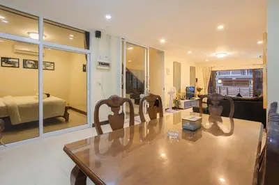 a living room with a table and chairs and a bedroom at First Ao Nang Private Pool Villa in Ao Nang Beach