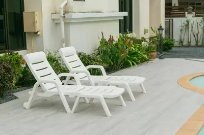 two white lounge chairs sitting next to a pool at First Ao Nang Private Pool Villa in Ao Nang Beach