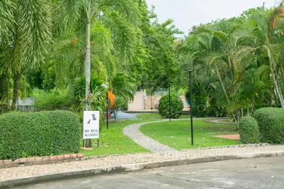 a walkway in a park with trees and a sign at First Ao Nang Private Pool Villa in Ao Nang Beach