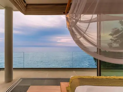 a bedroom with a view of the ocean at Baan Paa Talee Estate - SHA Extra Plus in Kamala Beach