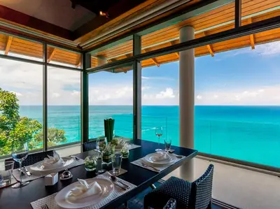 a dining room with a view of the ocean at Baan Paa Talee Estate - SHA Extra Plus in Kamala Beach