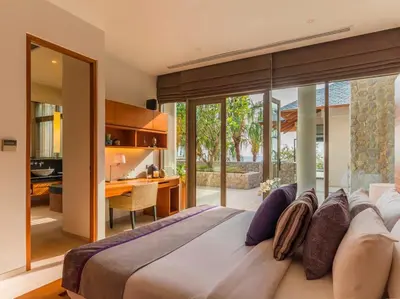 a bedroom with a large bed and a desk at Baan Paa Talee Estate - SHA Extra Plus in Kamala Beach