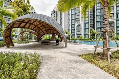 a wooden archway in a park with a building at The Title Halo1 350 m to NaiYang Brand-New 1BR in Nai Yang Beach