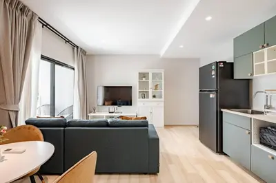 a living room with a couch and a kitchen at The Title Halo1 350 m to NaiYang Brand-New 1BR in Nai Yang Beach