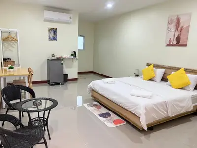 a bedroom with a bed and a table and chairs at Muttafa House in Nai Yang Beach