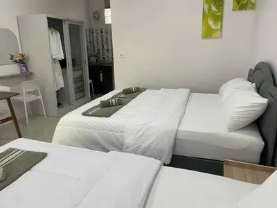 a hotel room with two beds and a table at Yada House Sunny Place in Ban Bo Han
