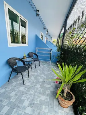 a patio with chairs and a table and a blue wall at Yada House Sunny Place in Ban Bo Han