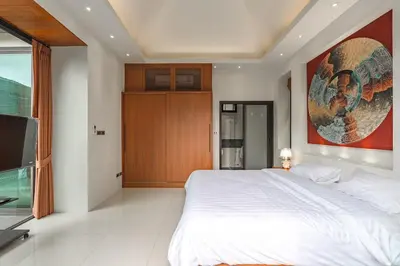 a bedroom with a large white bed and a television at V232 Private 4BR Pool Villa Near Big Buddha&Gym in Chalong