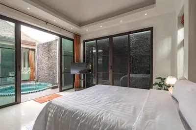 a bedroom with a large white bed and a swimming pool at V232 Private 4BR Pool Villa Near Big Buddha&Gym in Chalong