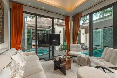 a living room with a white couch and a tv at V232 Private 4BR Pool Villa Near Big Buddha&Gym in Chalong