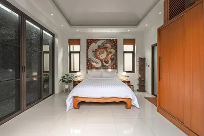 a bedroom with a large bed and a painting on the wall at V232 Private 4BR Pool Villa Near Big Buddha&Gym in Chalong
