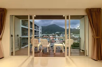 a room with a table and chairs on a balcony at C229 1BR Studio Sea View 850m to Beach Gym in Patong Beach