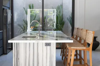 a kitchen with a counter with a sink and chairs at Andaman Paradise 1 - Luxury 3-Bedrooms Pool Villa in Rawai Beach