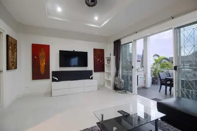 a living room with a flat screen tv on a wall at C230 Chill 1BR Sea View, Near Beach & Muay Thai in Rawai Beach