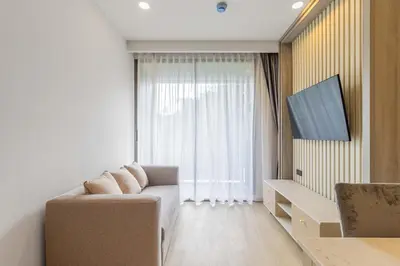 a living room with a couch and a large window at C231 Brand-New 1BR Prime Spot Pool&Gym Near Beach in Bang Tao Beach