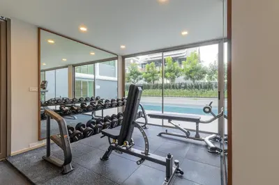 a gym with a row of exercise equipment and a mirror at C226 Brand-New Top Location Near Beach Clubs in Bang Tao Beach