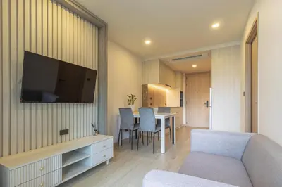 a living room with a couch and a television on a wall at C226 Brand-New Top Location Near Beach Clubs in Bang Tao Beach