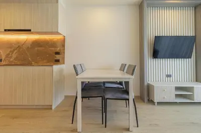 a table and chairs in a room with a tv at C227 Brand New Condo Near Top Phuket Beach Clubs in Bang Tao Beach