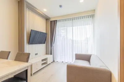 a living room with a couch and a tv and a window at C227 Brand New Condo Near Top Phuket Beach Clubs in Bang Tao Beach