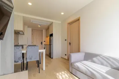 a kitchen and a living room with a table and chairs at C228 Brand New Condo Near Beach & Prime Location in Bang Tao Beach