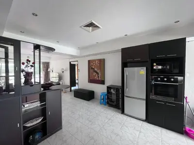 a kitchen with black cabinets and a stainless steel refrigerator at Rawai Condominium in Ban Saiyuan (1)