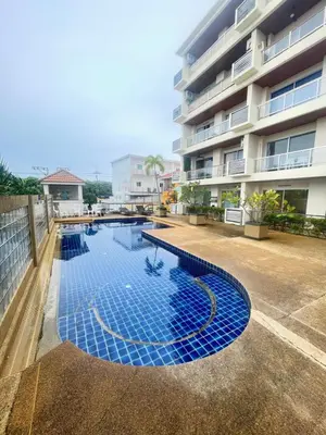 a swimming pool in front of a building at Rawai Condominium in Ban Saiyuan (1)
