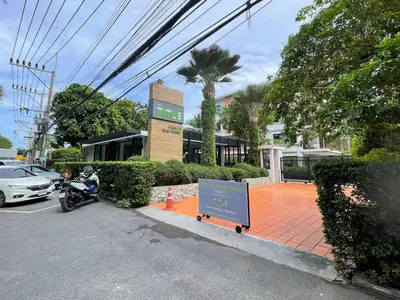 a motorcycle parked in front of a building with a sign at The Title Rawai Aparthotel by HSS in Rawai Beach