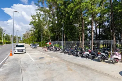 a row of motorcycles parked in a parking lot at Beachside 1 BR apartment by NLA in Bang Tao Beach