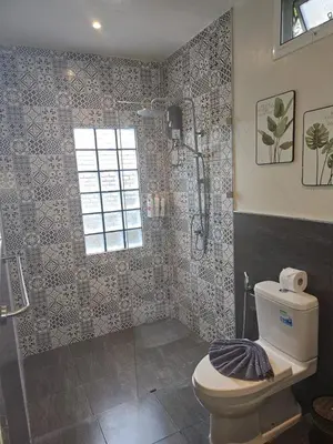 a bathroom with a toilet and a shower at Tropical Hideaway Close to the Beach in Ban Thalat Choeng Thale