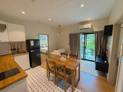 a kitchen and dining room with a table and a kitchen and a living room at FAMILY HOMES - Brand New 2BDRM Poolside Apartment in Phuket