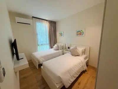 a hotel room with two beds and a window at FAMILY HOMES - Brand New 2BDRM Poolside Apartment in Phuket