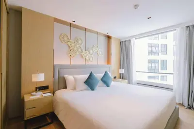 a bedroom with a large white bed with blue pillows at Stylish studio on Rawai beach in Rawai Beach