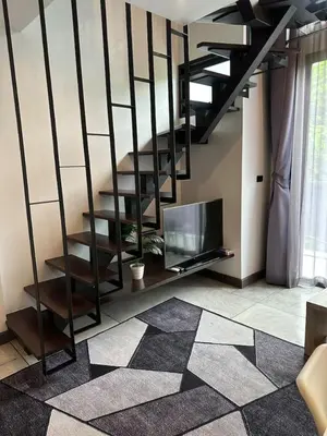 a living room with a staircase and a television at Modern apartment Utopia Naiharn (A22) in Rawai Beach