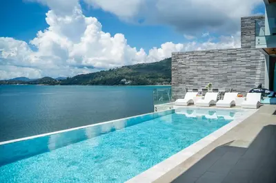 a swimming pool with a view of a body of water at Kamala Beach Front Sea View 6 Bedroom Villa in Kamala Beach