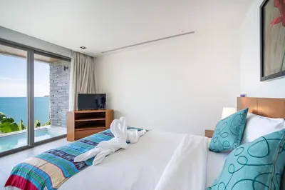 a bedroom with a bed and a large window at Kamala Beach Front Sea View 6 Bedroom Villa in Kamala Beach
