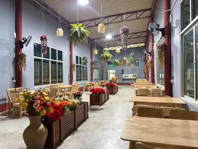 a restaurant with tables and chairs and flowers in a room at Guitar Thai Style Pool House in Ao Nang Beach