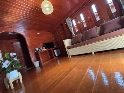 a living room with couches and a wooden wall at Guitar Thai Style Pool House in Ao Nang Beach
