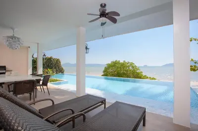 a dining room with a view of the ocean at Fisherman Way Beach Villa in Rawai Beach