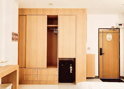 a large wooden cabinet with a refrigerator in a room at Laksika Place Khao Rang in Phuket Town