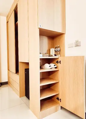 a kitchen with wooden cabinets and shelves in a kitchen at Laksika Place Khao Rang in Phuket Town