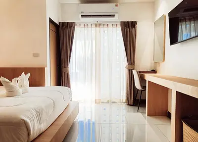 a hotel room with a bed and a window at Laksika Place Khao Rang in Phuket Town