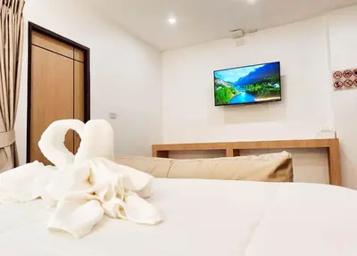 a bedroom with a bed with a tv on the wall at Laksika Place Khao Rang in Phuket Town