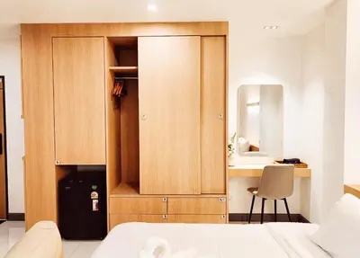 a bedroom with a bed and a desk and a mirror at Laksika Place Khao Rang in Phuket Town
