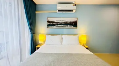 a bedroom with a bed with white pillows at Cozy condo maikhao Phuket in Ban Mai Salae