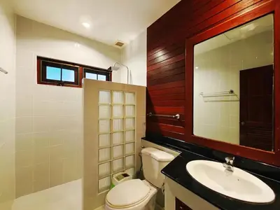 a bathroom with a toilet and a sink and a mirror at Secure 3 Bedroom Villa near beach in Kamala Beach